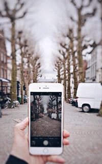 Man photographing with smart phone on street
