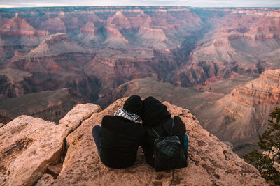 Rear view of couple sitting on rock formation at grand canyon national park