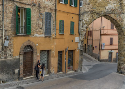 People walking on footpath amidst buildings in city