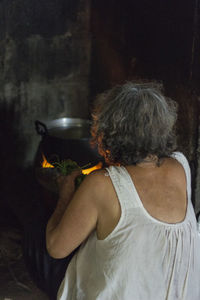 Rear view of woman sitting at home