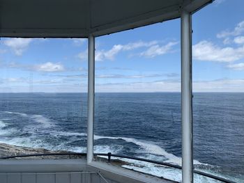 View of sea against sky seen through window