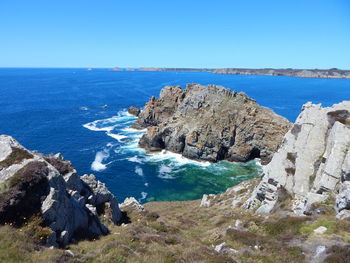 Scenic view of sea seen from cliff against sky