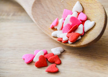 High angle view of heart shape candies in wooden spoon