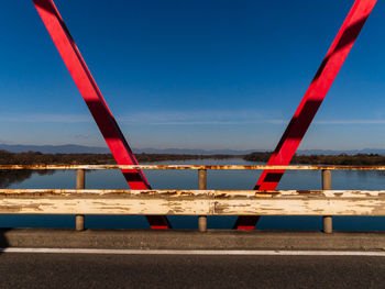 Bridge over sea against clear blue sky