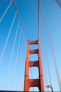 Low angle view of golden gate bridge in front of blue sky. industrial look