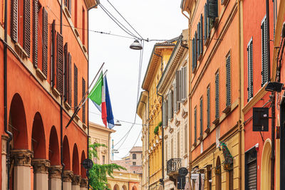 Low angle view of flags and buildings against sky