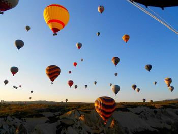 Hot air balloons over cappadocia against sky