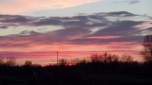 Scenic view of dramatic sky over silhouette landscape