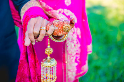 Close-up of hand holding pink flower