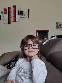 Portrait of girl sitting on sofa at home