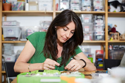 Mature female engineer working at table in workshop