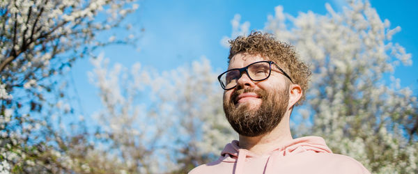 Portrait of young man wearing sunglasses against sky