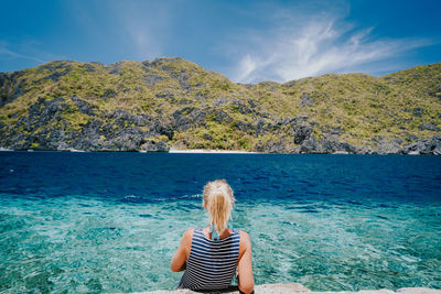 Rear view of woman in sea against sky