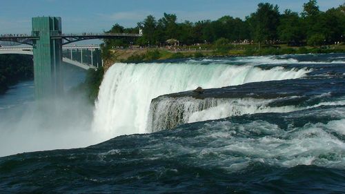 Scenic view of waterfall against sky