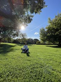 Man on field against sky on sunny day