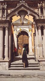 Full length rear view of man outside temple in building