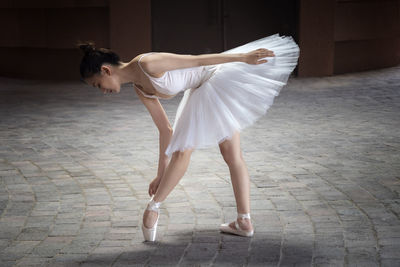 Full length of ballet dancer dancing outdoors