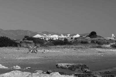 Houses on field by mountain against clear sky