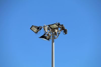 Low angle view of floodlight against clear blue sky