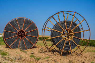 Ferris wheel on field against clear blue sky