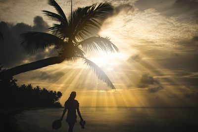 Silhouette man at beach during sunset