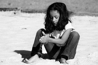 Girl playing with sand at beach