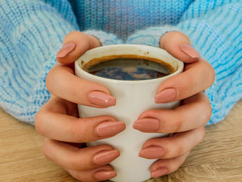 Close-up of hand holding tea cup