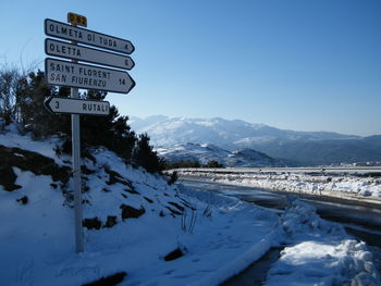 Arrow symbols with text at snow covered roadside