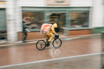 Man riding bicycle on road in city