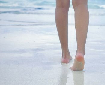 Low section of woman standing on beach