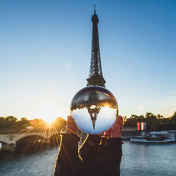 Person with tower against sky during sunset