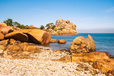 Rock formation on beach against sky