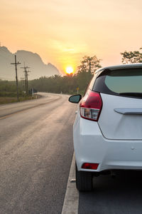 Car on road against sky during sunset