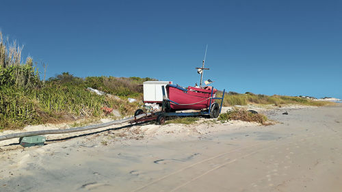 Lifeguard hut on beach against clear blue sky