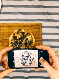 Directly above shot of person photographing food on table