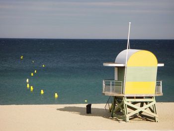 Lifeguard hut on beach against sky