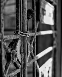 Close-up of rusty metal tied to fence