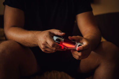 Midsection of man playing video game at home