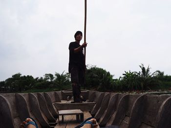 Man standing by palm trees against sky