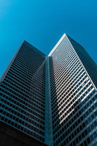 Low angle view of modern buildings against clear blue sky