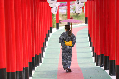 Rear view of women standing on red outside building