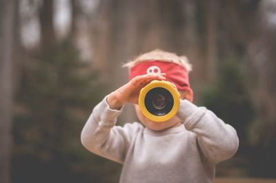 Close-up portrait of boy holding telescope