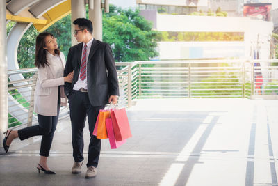 Couple standing on footbridge in city