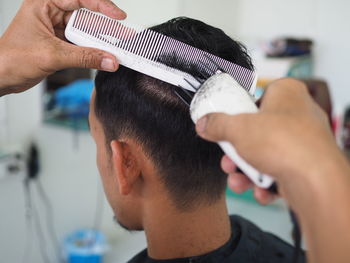 Close-up of barber cutting hair in salon