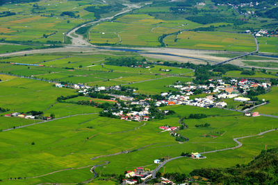 High angle view of green landscape against houses