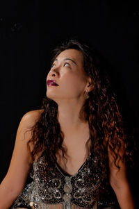 Woman with long hair against black background