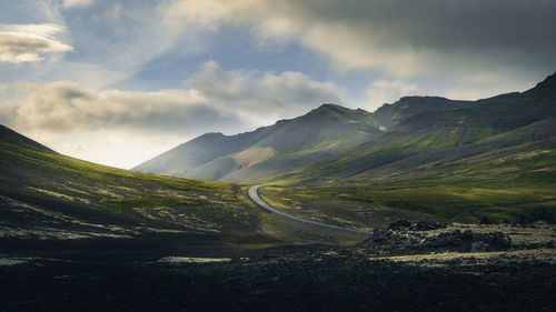 Panoramic view of scenic driving road leading through volcanic mountain landscape, iceland