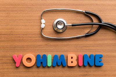 Directly above shot of stethoscope with yohimbine text on wooden table