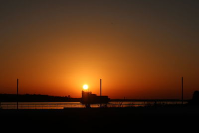 Silhouette boat on beach against sky during sunset