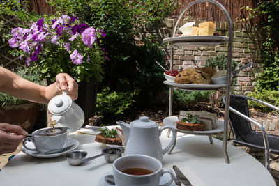 Coffee cup on table by potted plants